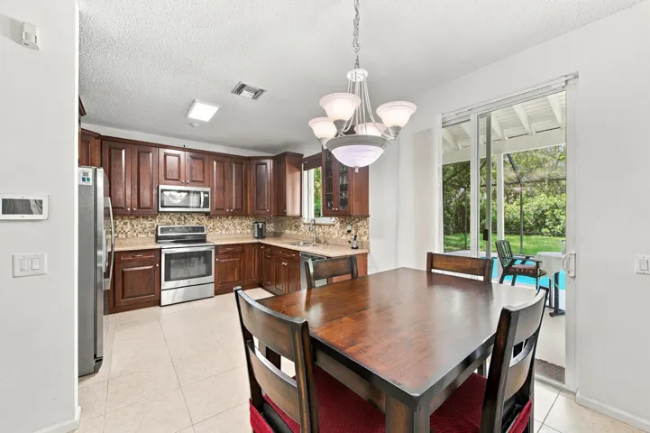 Kitchen featuring wood cabinetry, stainless steel appliances, and a mosaic tile backsplash
