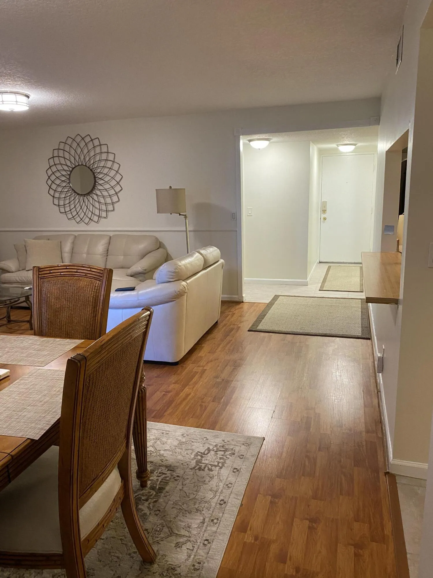 Wood-finish flooring throughout the main level with wall-mounted lighting fixtures