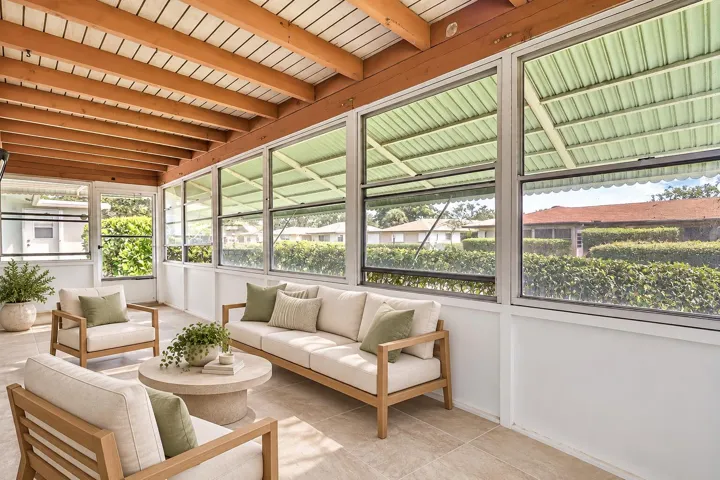Screened porch with exposed wood beam ceiling, tile flooring, and multiple awning windows
