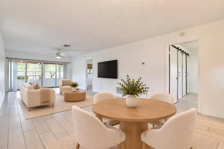 Open-concept living area with light-toned flooring and a ceiling fan