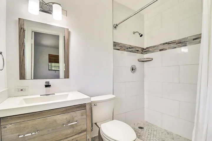 Vanity with wood-finish cabinetry, integrated sink, and chrome faucet