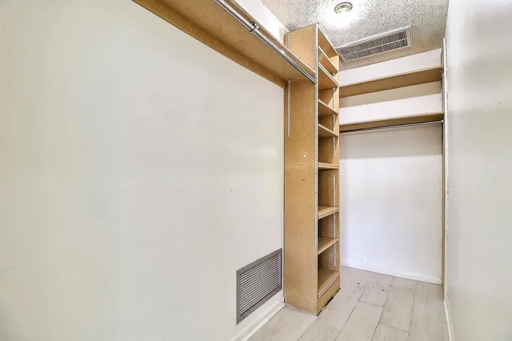 Built-in shelving, hanging rods, wood-finish flooring, recessed lighting