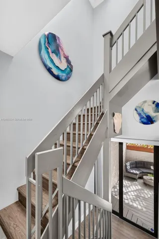 Gray Laminate Wood Flooring on the Stairs Adds to the Townhouse's Upscale Look and Well Lit with the Skylight Above the Stairs