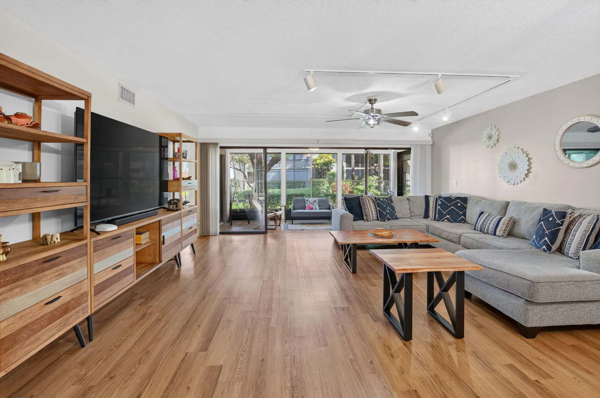 Wood-finish flooring throughout, ceiling fan with integrated lighting, and track lighting fixtures