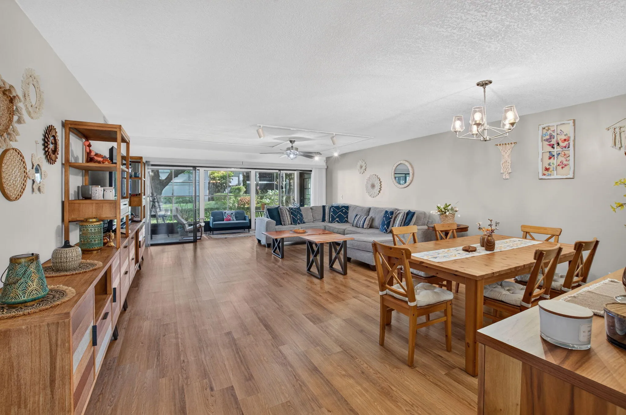 Expansive main living area featuring wood-finish flooring, and a contemporary chandelier