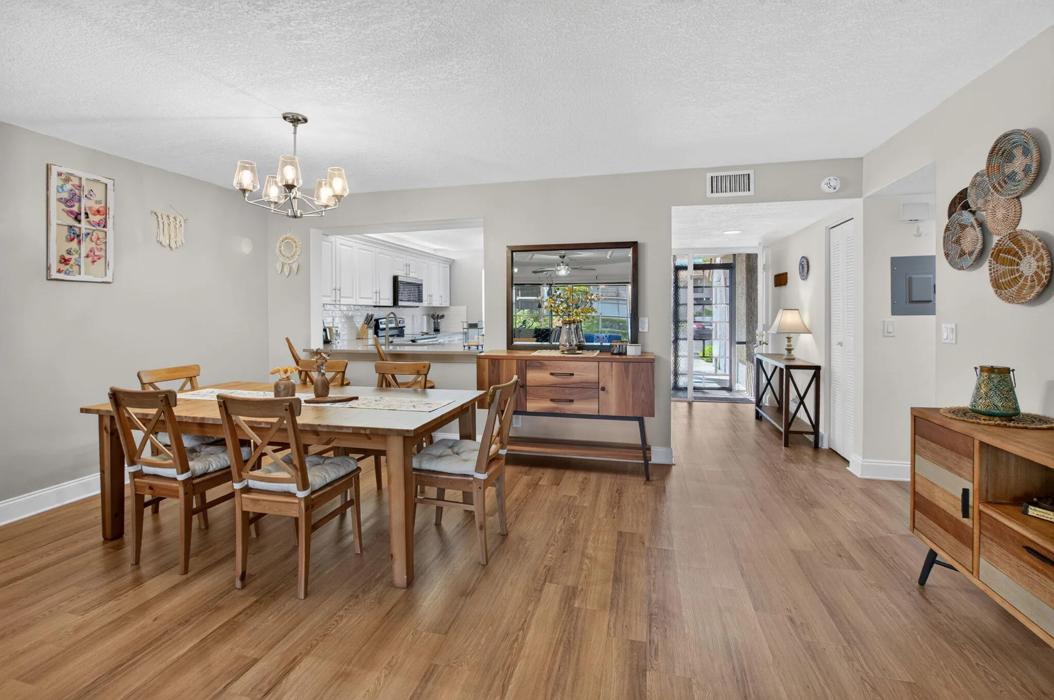 Wood-finish flooring throughout, with a dining area featuring a modern chandelier