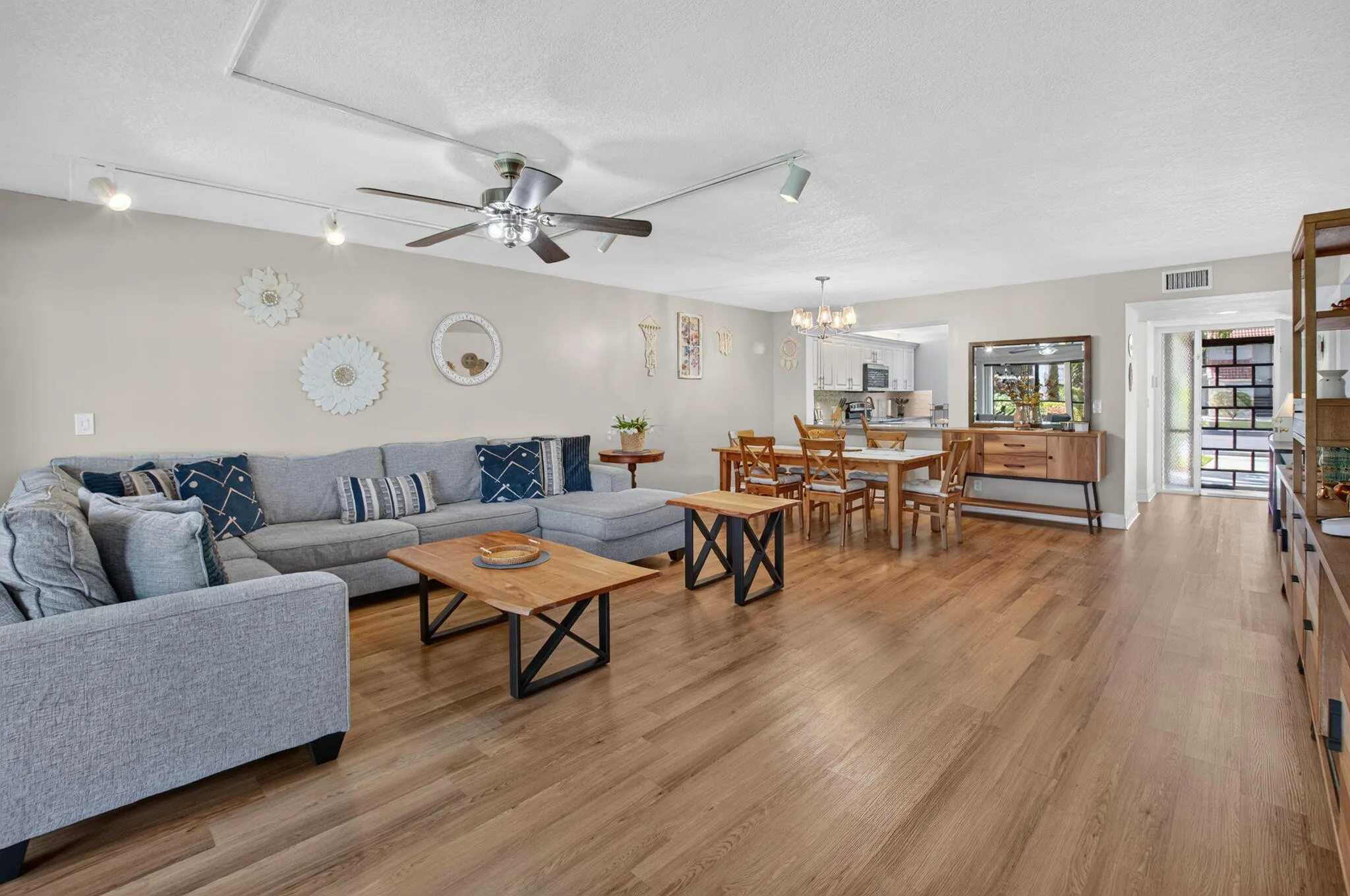Spacious open-concept living area featuring wood-finish flooring, recessed lighting, and ceiling fan