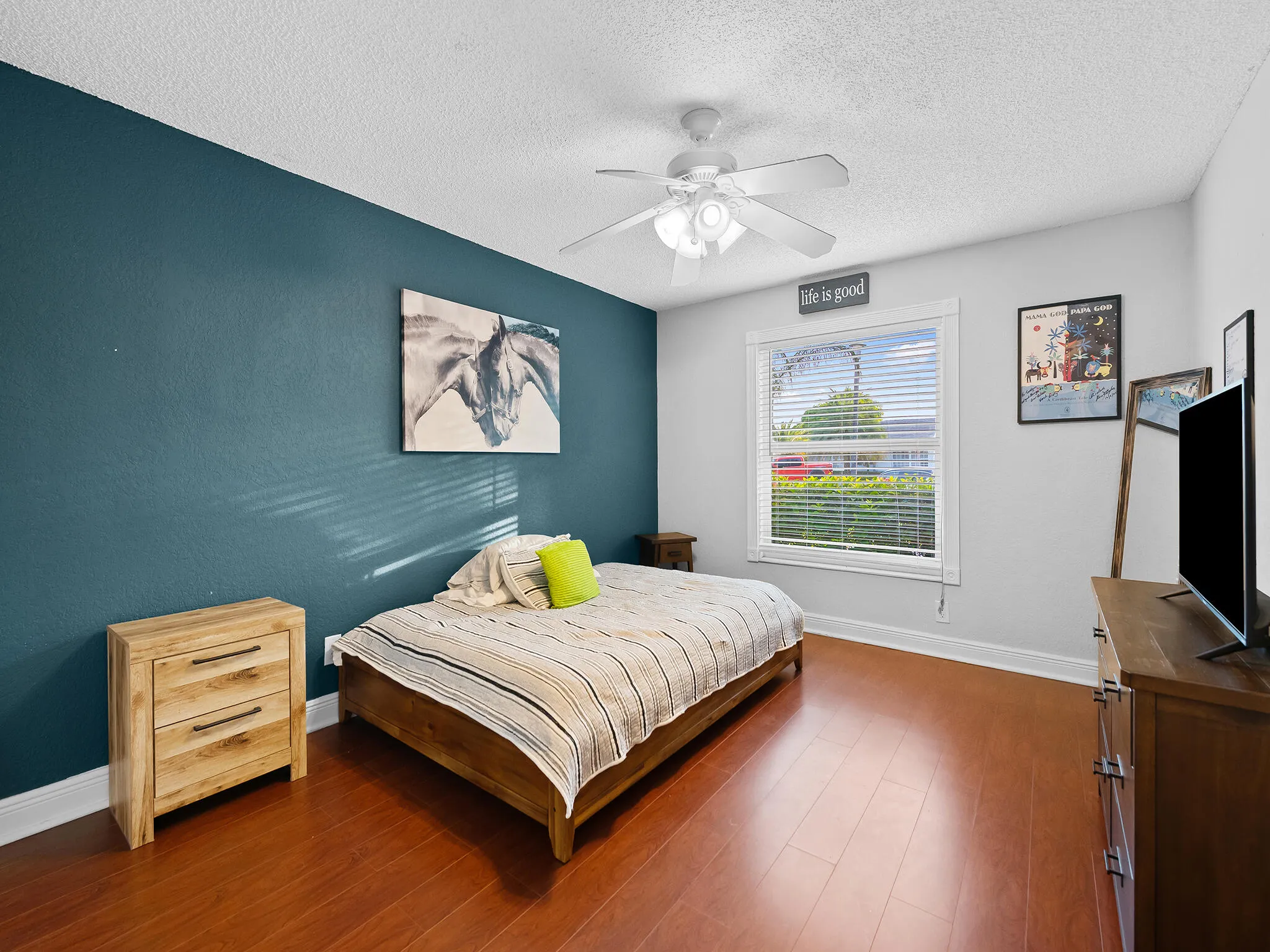 Second guest room with bold teal accent wall.