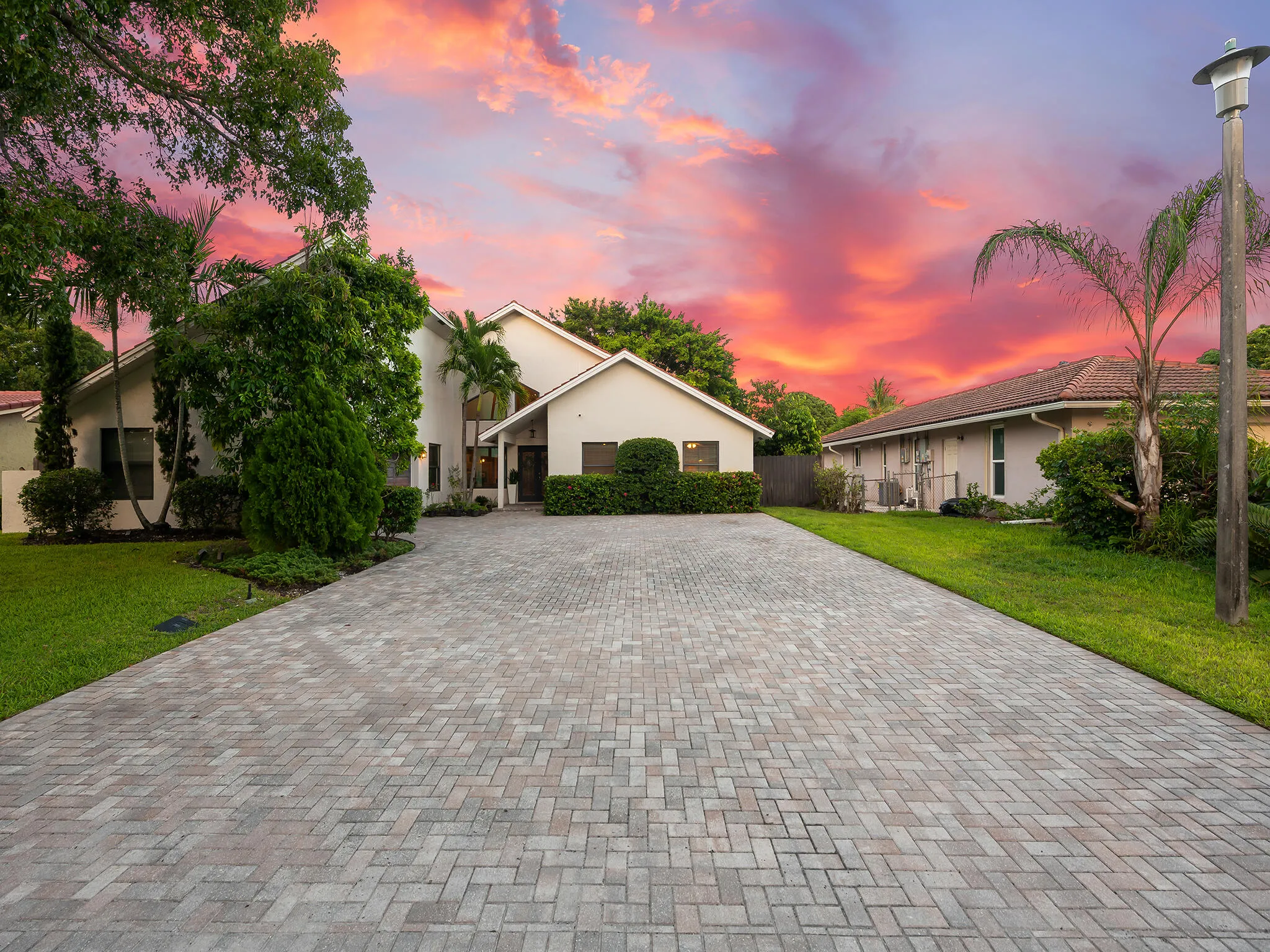 Paver driveway framed by manicured landscaping.