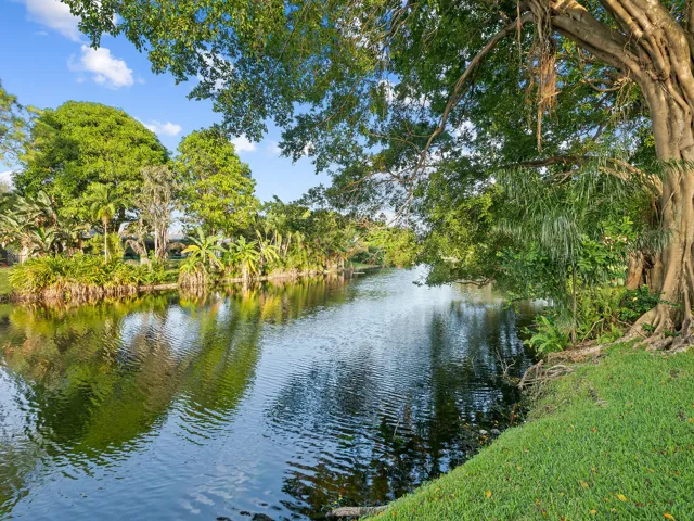 Mature canopy shades the canal side lawn.