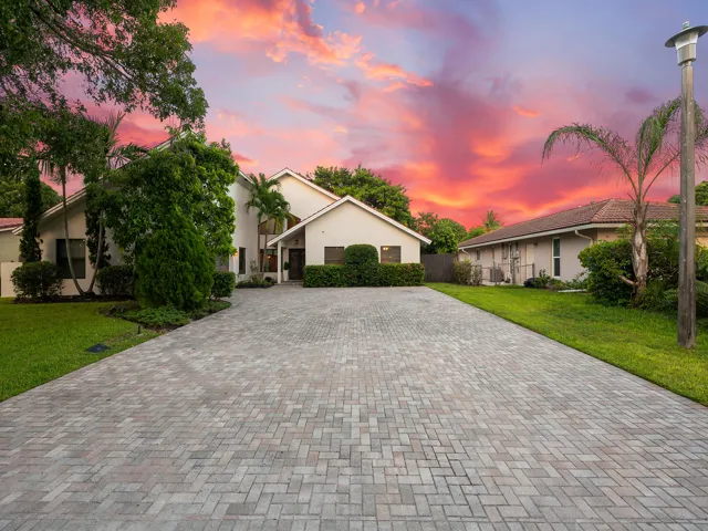 Paver driveway framed by manicured landscaping.