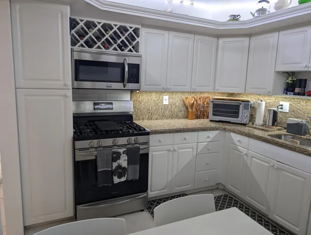 Kitchen Featuring Granite Top & Stainless Steel Appliances