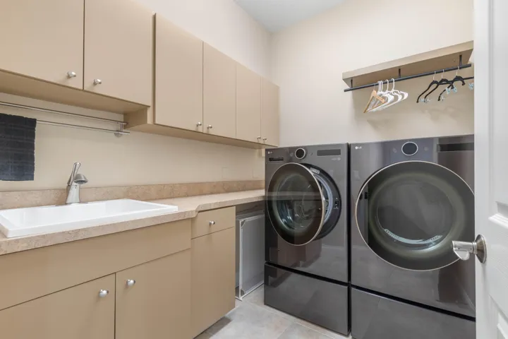 And because everyday life deserves its own well-planned space, the laundry room delivers with a utility sink, generous cabinetry, counter space and room to hang and organiz