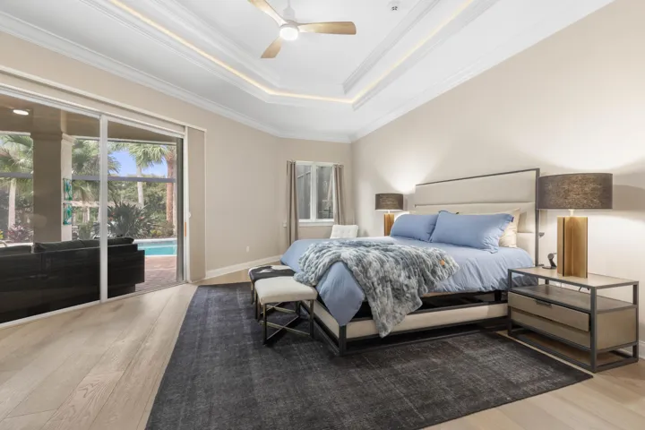 The primary suite feels like its own private escape, where mornings begin with a glimpse of the pool and evenings end beneath the soft glow of the tray ceiling.