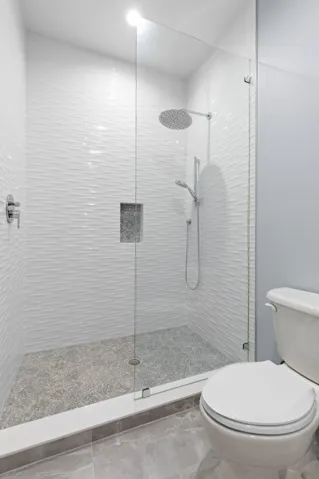 Guest Suite #3 continues with a beautifully updated shower, where wave-textured tile, a rainfall showerhead and handheld fixture bring a little spa-inspired indulgence to your guests’ stay.