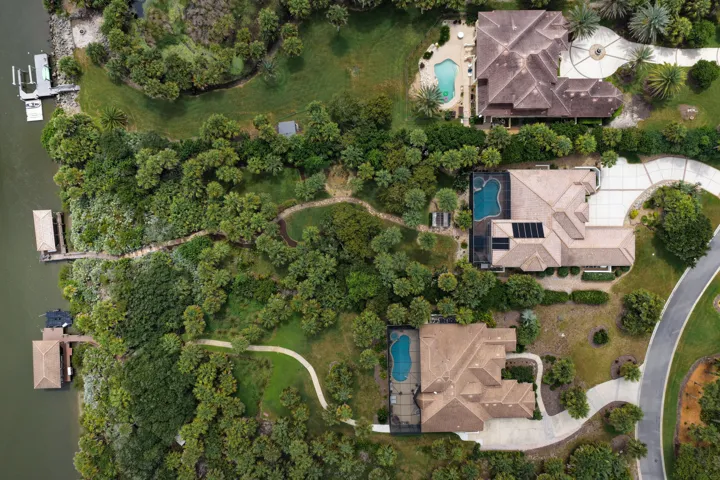 A winding walkway meanders through the lush, park-like grounds, creating a beautiful journey from home to water’s edge, where your private covered dock awaits for the next adventure