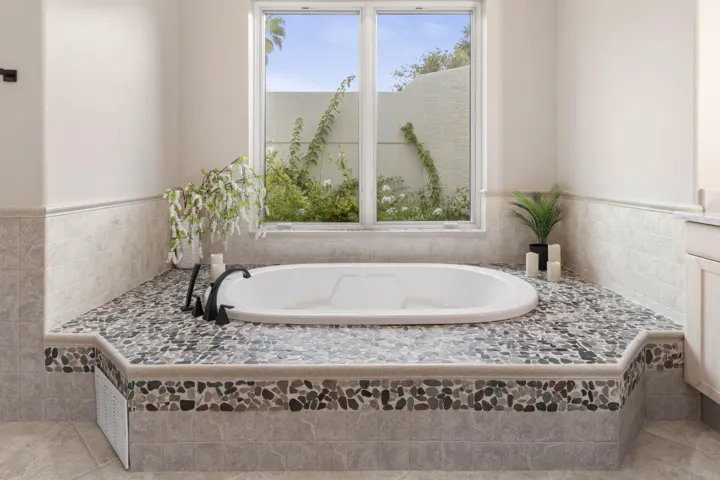 The kind of tub that makes you want to stay awhile—beautiful pebble-stone detailing turns an everyday soak into something a little more indulgent.