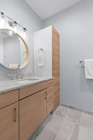The ensuite bath continues the suite’s fresh, polished feel with sleek cabinetry, generous storage and a crisp contemporary finish