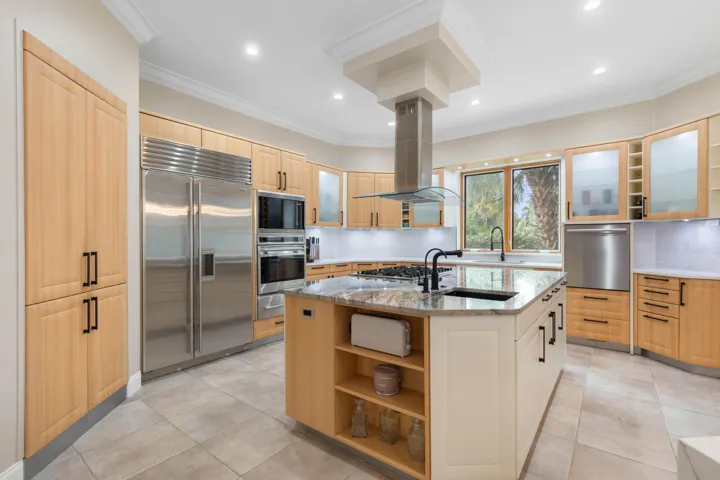 A chef’s dream kitchen where sleek custom cabinetry, gleaming stone surfaces, and professional-grade appliances come together in a symphony of modern elegance and effortless sophistication.