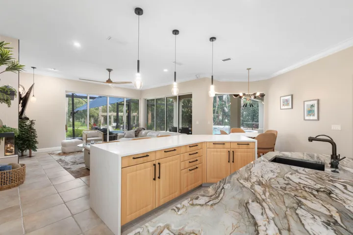 From meal prep to movie night, this open arrangement keeps the day connected, with generous counter space and a clear sightline from the kitchen to the family room and pool beyond.