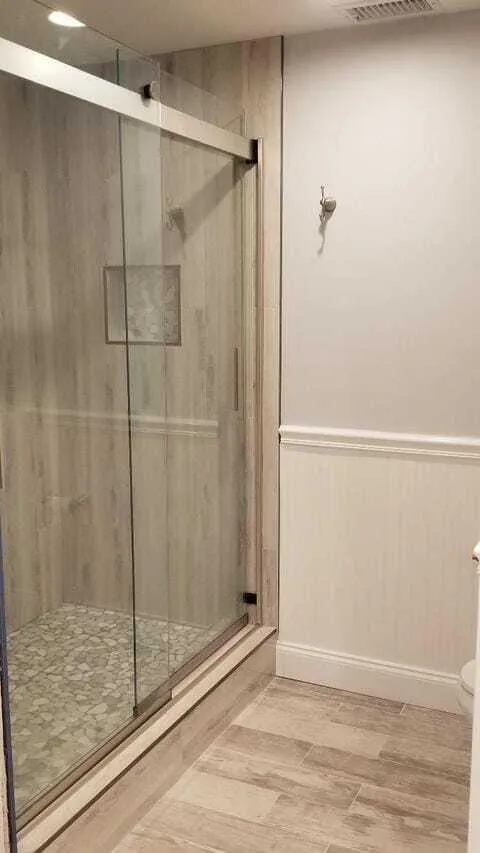 Seamless shower door and decorative bead board in bathroom