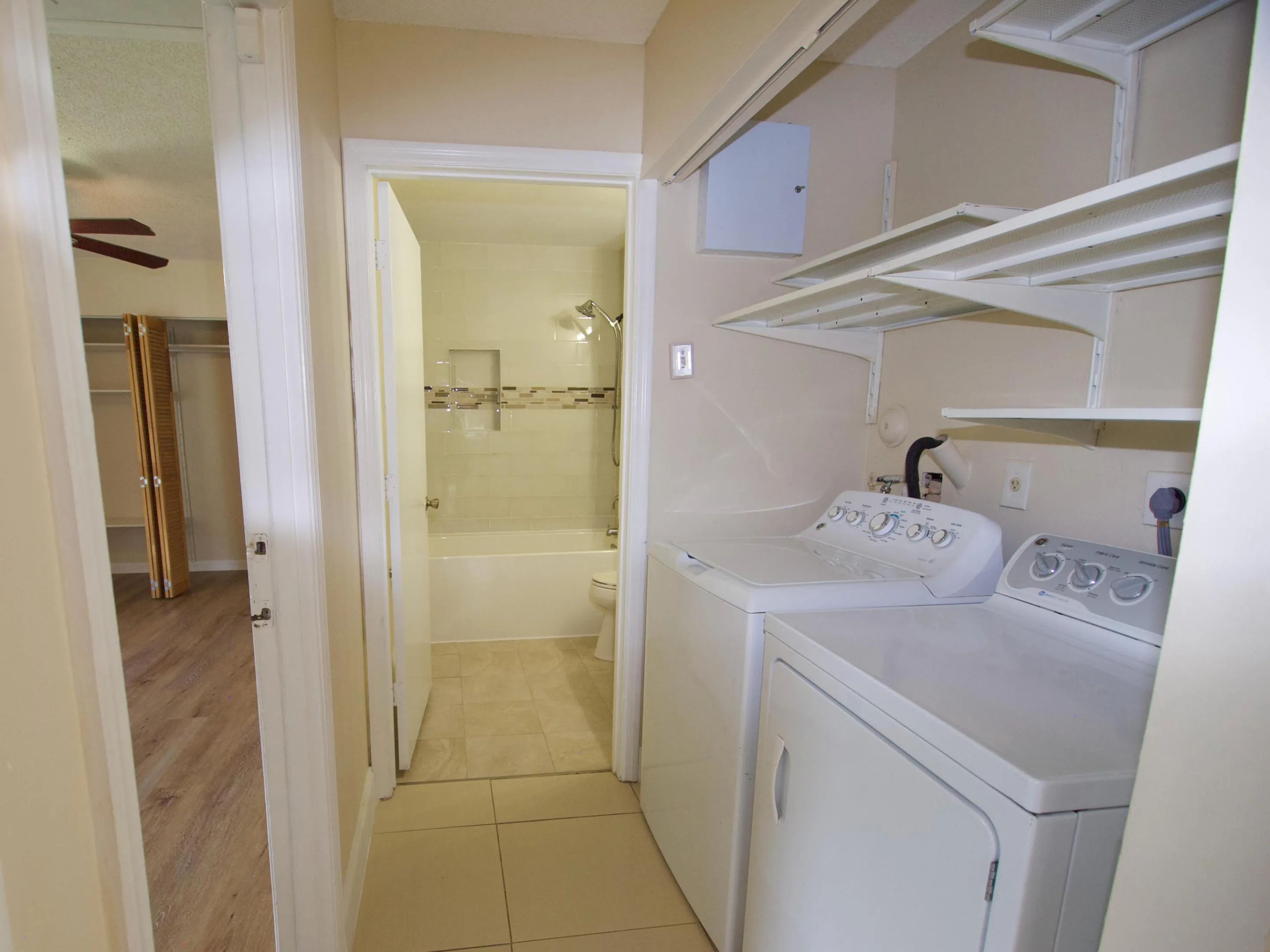 Laundry area with overhead shelving, tile flooring, and integrated full-size appliances