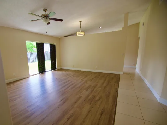 Spacious interior with wood-finish flooring, vaulted ceilings, and a modern ceiling fan