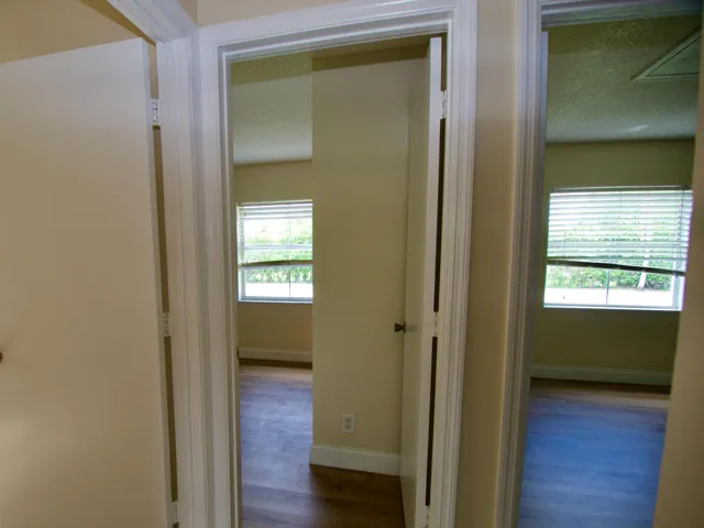 Wood-finish flooring with white trim and baseboards