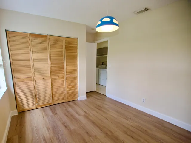 Wood-finish flooring throughout, light-toned walls, and louvered bifold closet doors