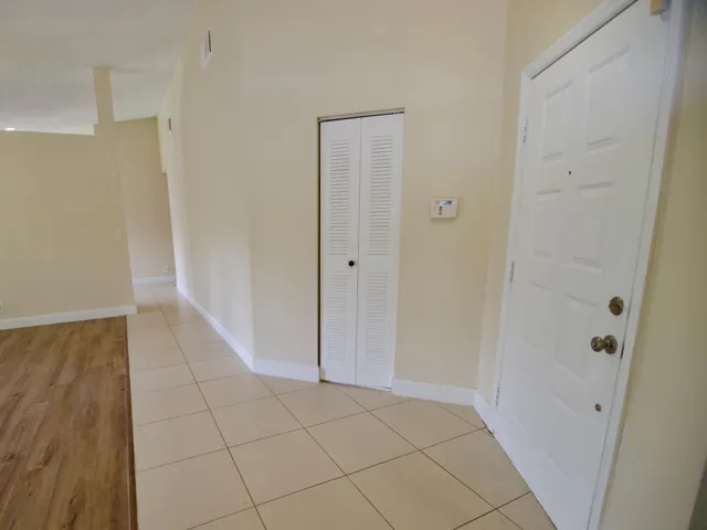 Cream-toned wall paint throughout, tile flooring, and wood-finish flooring
