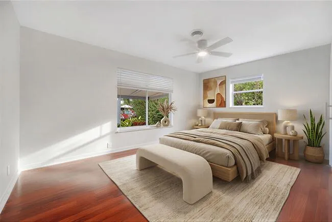 Virtually staged. Wood-finish flooring, white walls, louvered door, modern ceiling fan, and white trim