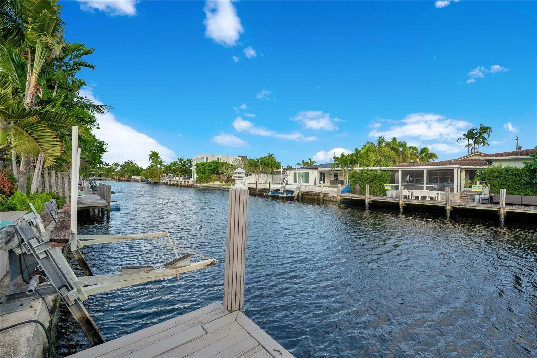Waterfront property featuring a private dock and lush tropical landscaping