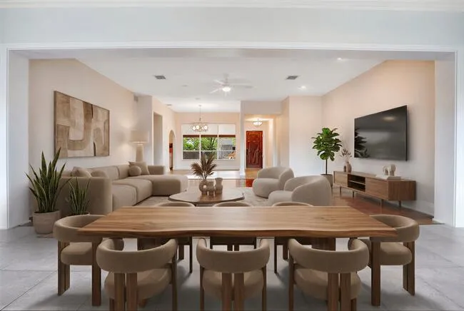 Virtually Staged. Great Room featuring expansive windows, tile flooring, white brick-finish walls, and a track lighting fixture