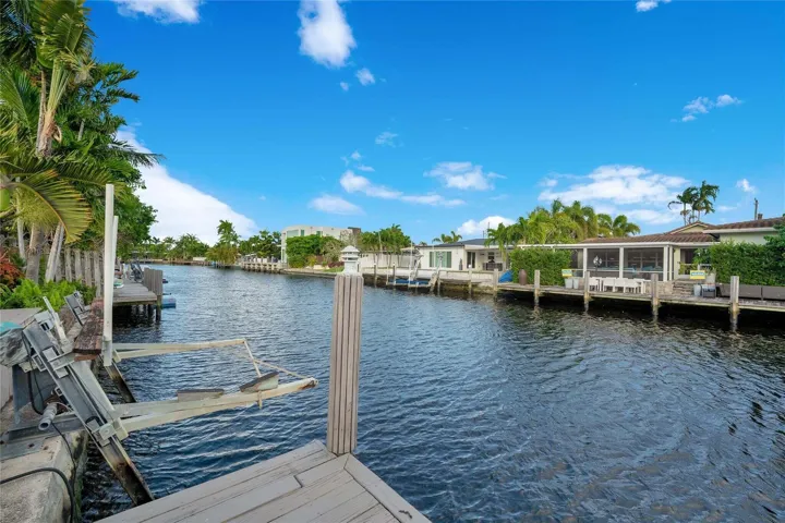 Waterfront property featuring a private dock and lush tropical landscaping