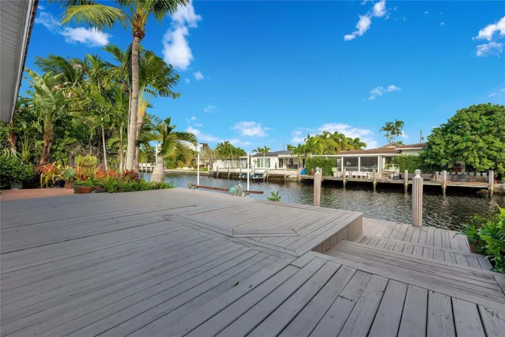 Expansive wooden deck with multi-level design and direct canal access. Two fixed bridges to intercoastal