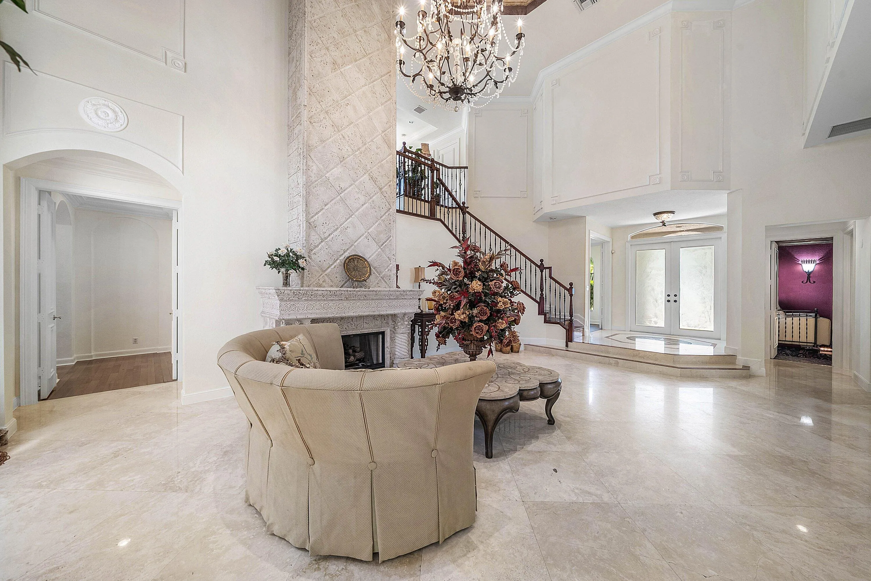 Two-story living room with marble flooring and a grand gas fireplace