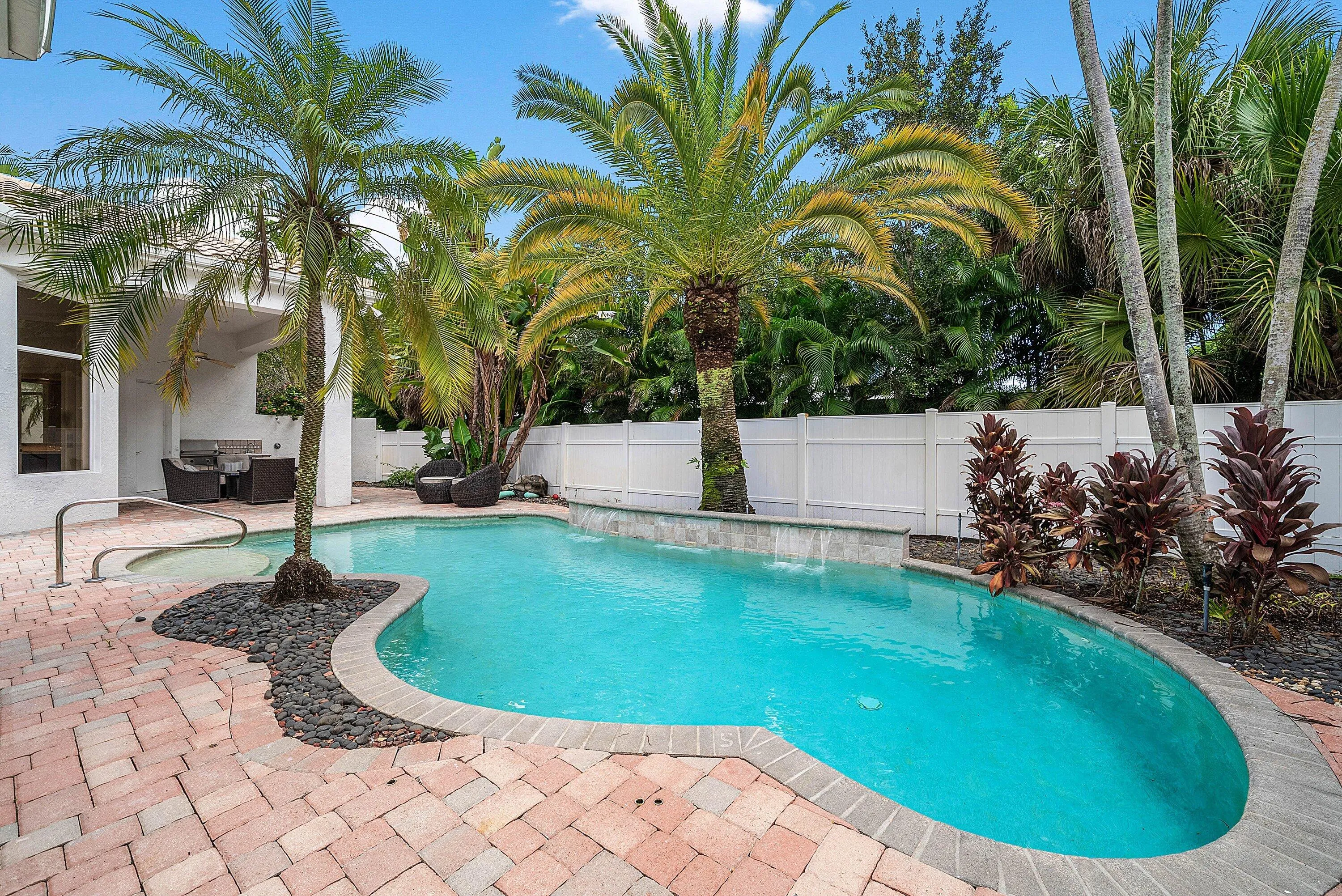 Paver patio surrounding a freeform swimming pool