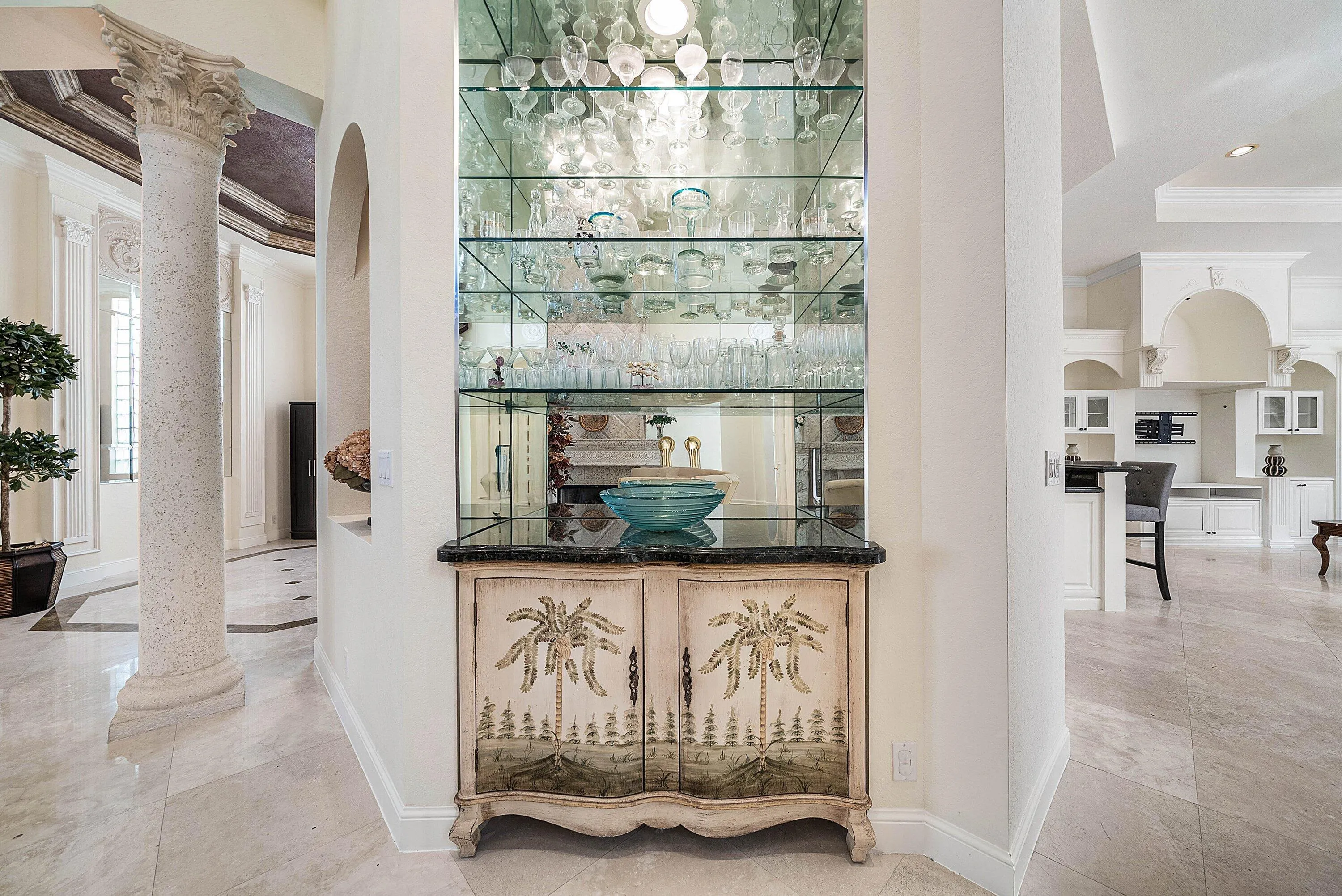 Built-in wet bar with glass shelving, mirrored backing