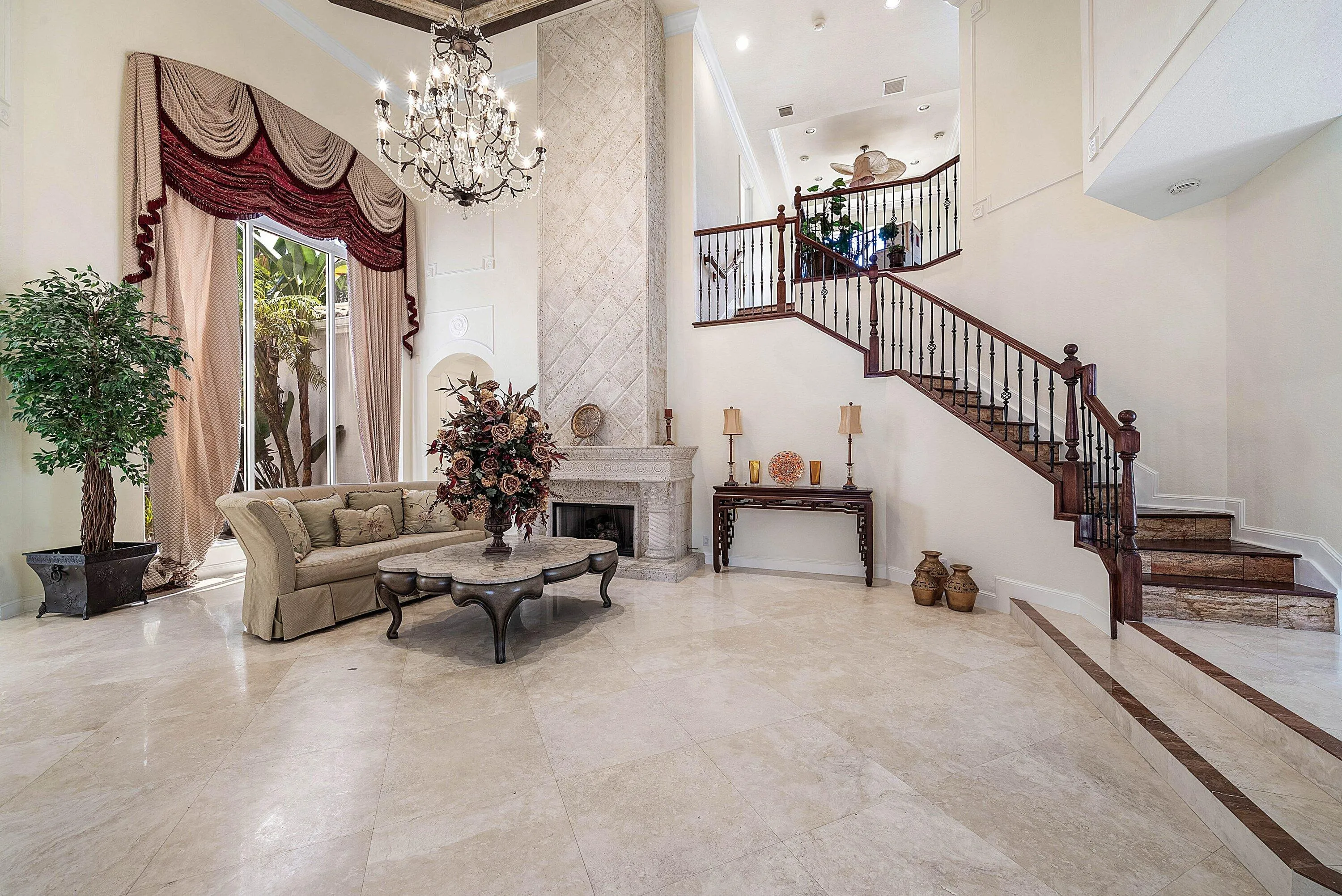 Two-story living room with marble flooring and a grand gas fireplace