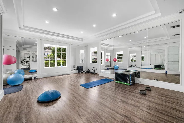 Spacious room featuring expansive mirrored wall, tray ceiling - invite your personal trainer