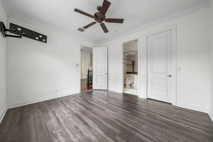 En-Suite bedroom #3 with wood-finish flooring throughout, crown molding, and a ceiling fan