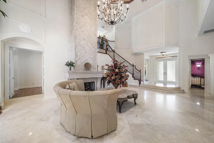 Two-story living room with marble flooring and a grand gas fireplace