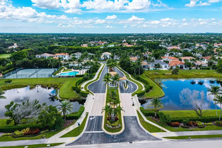 Gated community (24/7 manned) entrance with surrounding water features, and lush landscaping