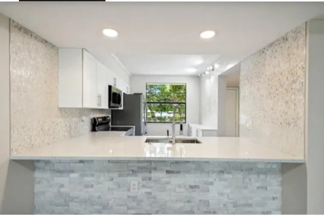 Beautiful White kitchen w/ stone wall decor