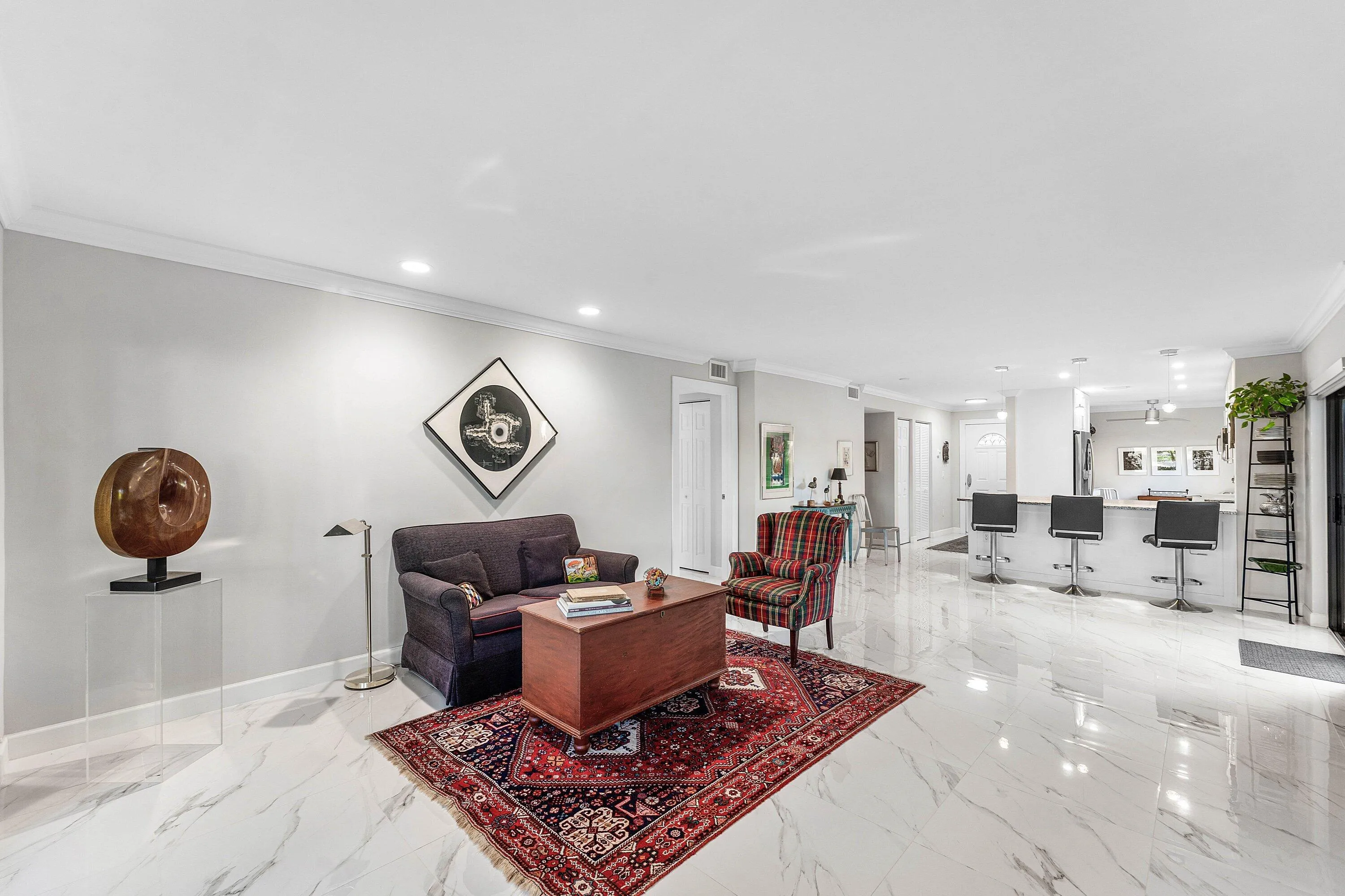 Recessed lighting, crown molding, and light-toned walls complement the polished tile flooring