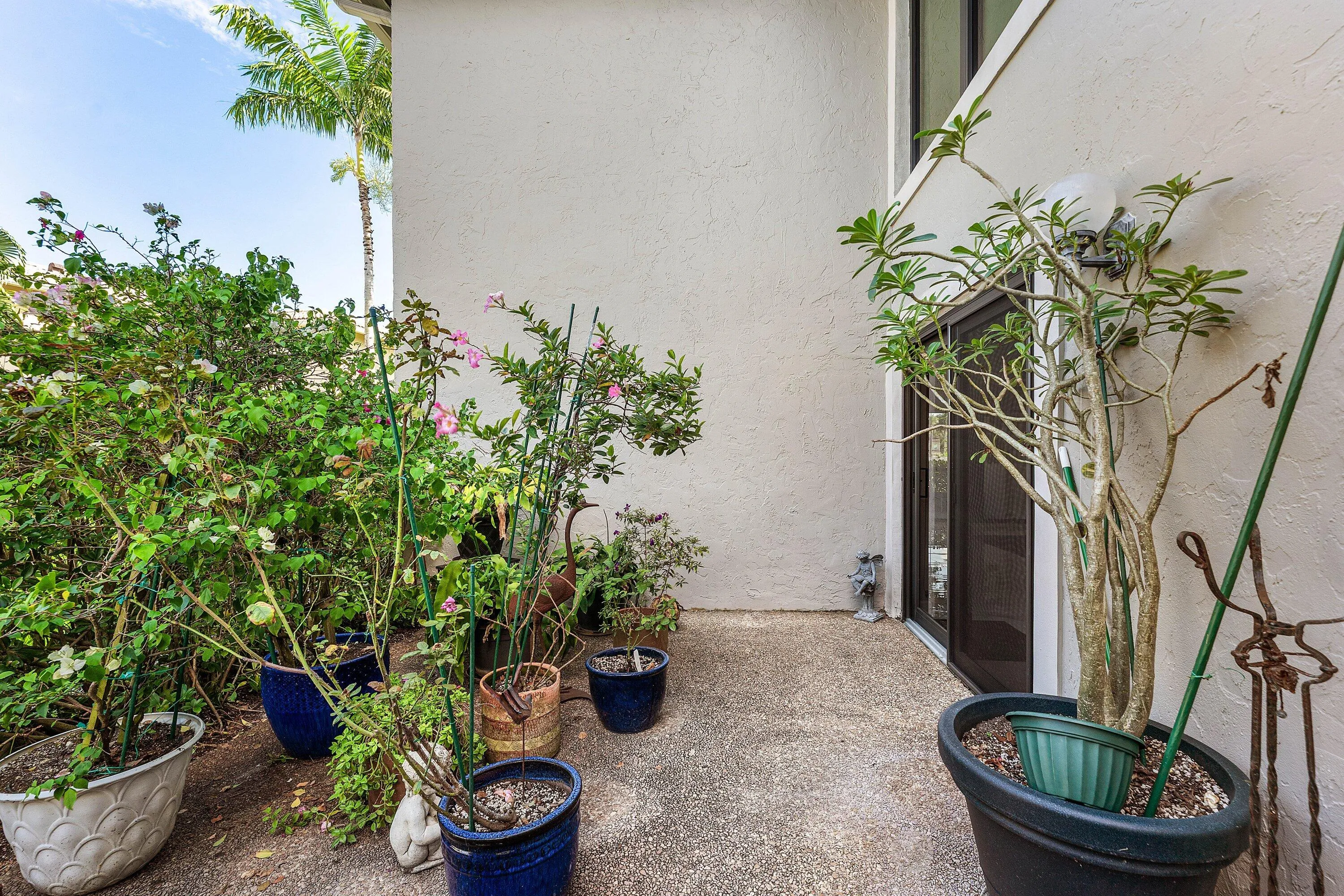 Outdoor patio with textured concrete flooring, stucco exterior, and a glass-paneled entry door