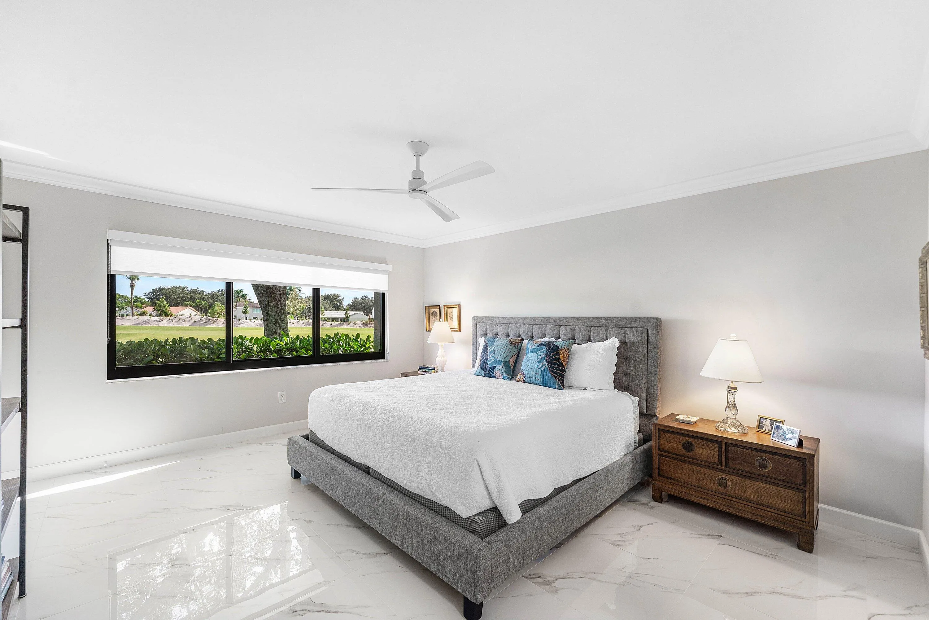 White tile flooring, expansive window with exterior scenery, crown molding, and a ceiling fan