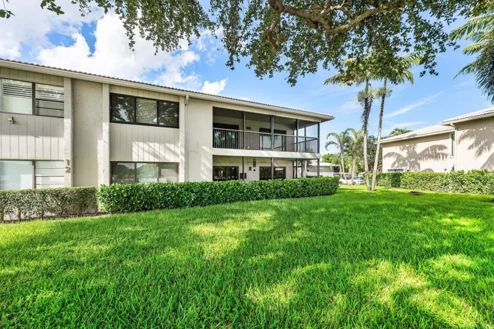Manicured lawn with dense green hedging and mature trees