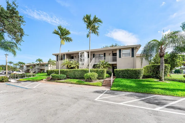 Exterior featuring multiple residential units, balconies, and lush landscaping