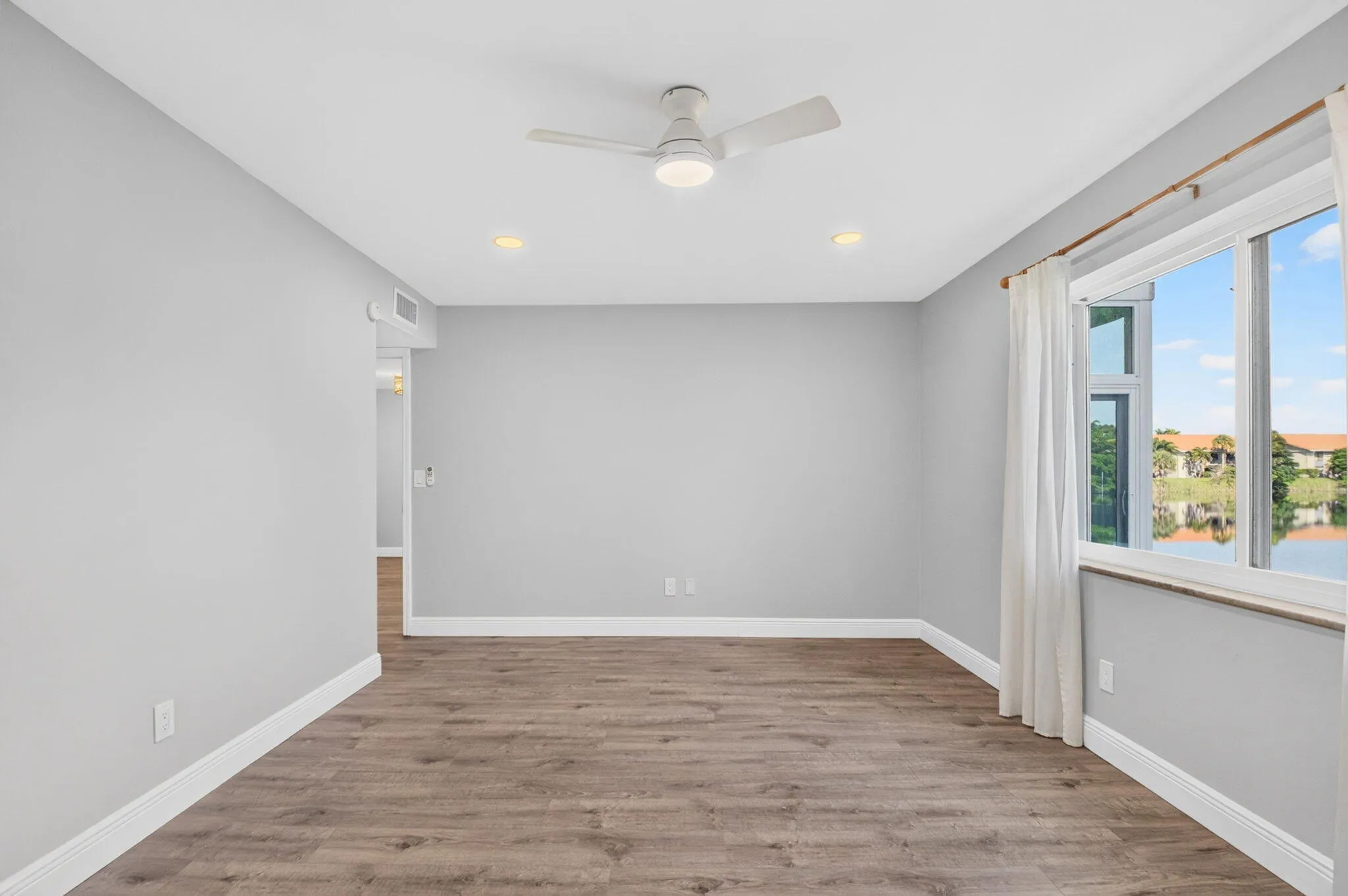 Primary Bedroom w Lake View, Impact Window, New Ceiling Fan, New Window Treatments